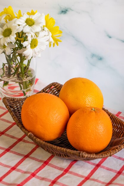 Orangen in einer Platte auf der karierten Tischdecke