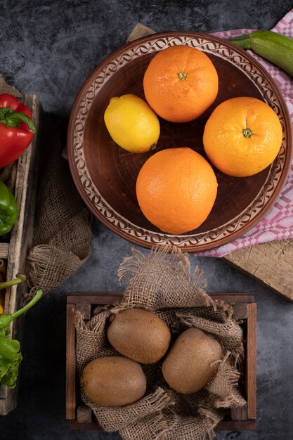 Orangen und Kiwies in rustikalen Platten.