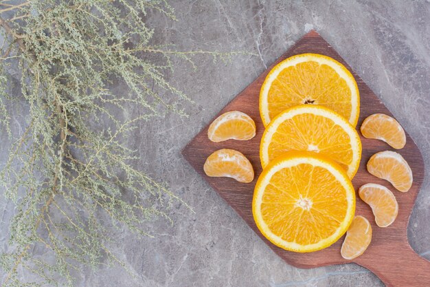 Orangen- und Mandarinenscheiben auf Holzbrett.