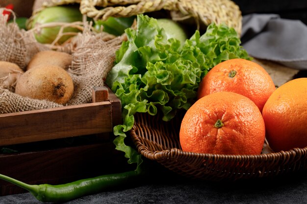 Orangen und Zitronen mit Salatblättern in einem rustikalen