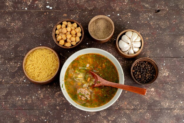 Orangengemüsesuppe von oben mit Gewürzen und Knoblauch auf braunem Suppenbrot