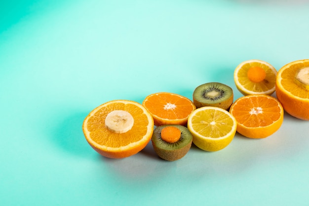 Orangenhälften Kiwi und Zitronen auf einem blauen Tisch