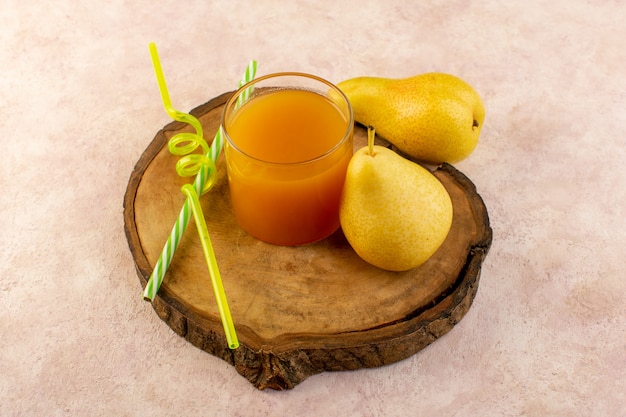 Orangensaft der Draufsicht in kleinem Glas mit Strohhalmen und frischer Birnenfrischkühlung lokalisiert auf dem braunen hölzernen Schreibtisch und rosa Hintergrundgetränkfrucht