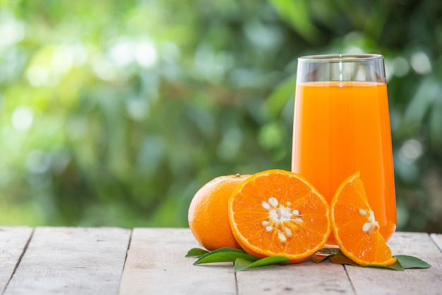 Orangensaft in einem Glas mit Orangen
