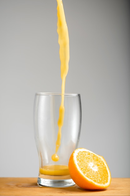 Orangensaft in Glas gießen