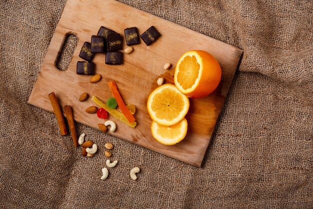 Orangenzimt und Nüsse der Pralinen auf Holzschreibtisch.