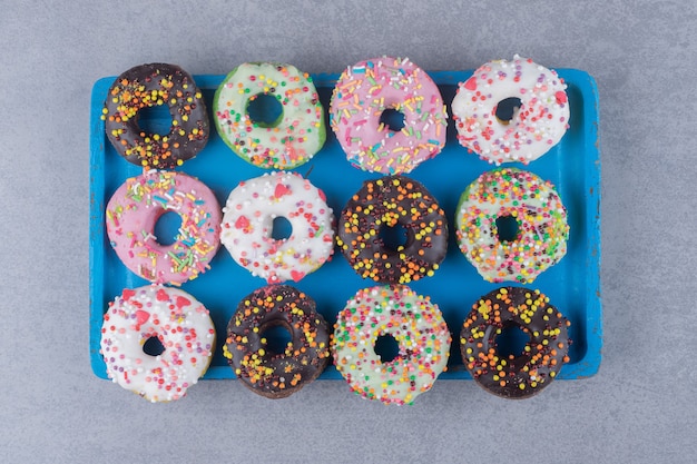 Ordentlich angeordnete donuts auf einer platte auf marmoroberfläche