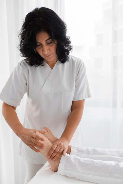 Osteopath, der eine junge Frau behandelt