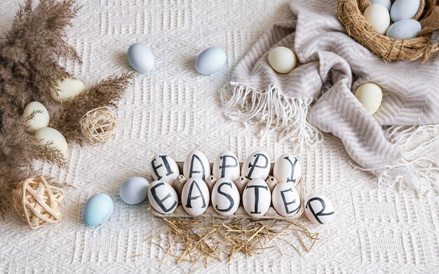 Ostereier mit der Aufschrift Frohe Ostern, Feiertagsdekor. Stillleben mit gemütlicher Osterstimmung.