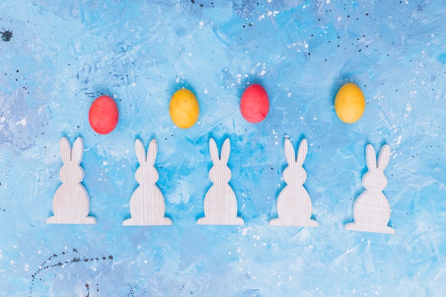 Ostereier mit hölzernen Kaninchen auf Tabelle