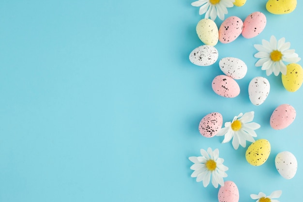 Ostereinladung mit Eiern und Gänseblümchen auf einem blauen Hintergrund mit Kopienraum