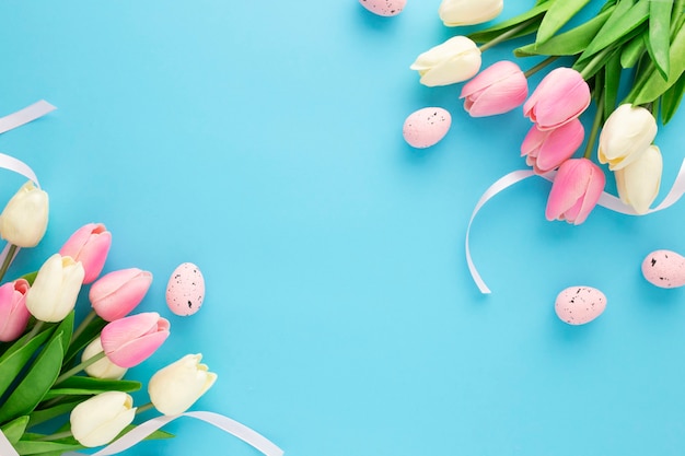 Ostereinladung mit tulpen auf einem blauen hintergrund mit kopienraum