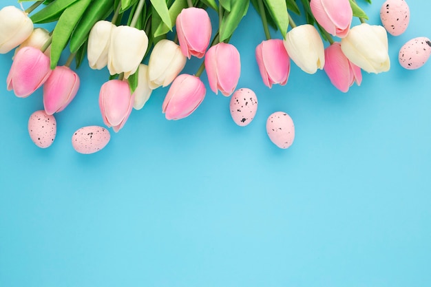 Ostereinladung mit tulpen auf einem blauen hintergrund mit kopienraum