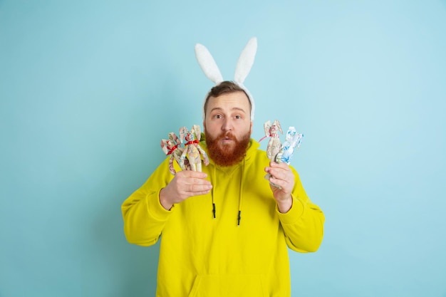 Osterhasenmann mit hellen Emotionen auf blauem Studiohintergrund