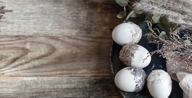 Osterkomposition mit dekorativen eiern auf einem hölzernen oberflächenkopierraum.