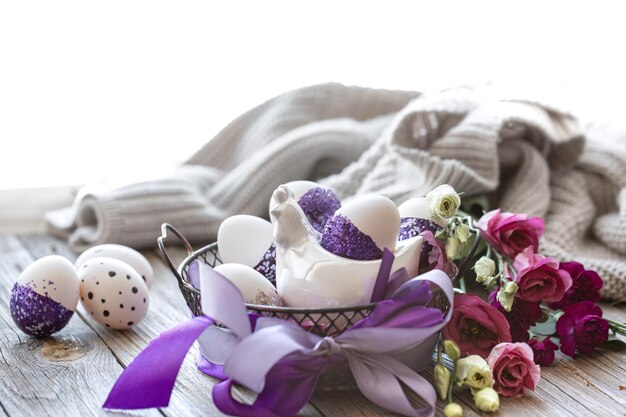 Osterkomposition mit mit lila Glitzern verzierten Eiern