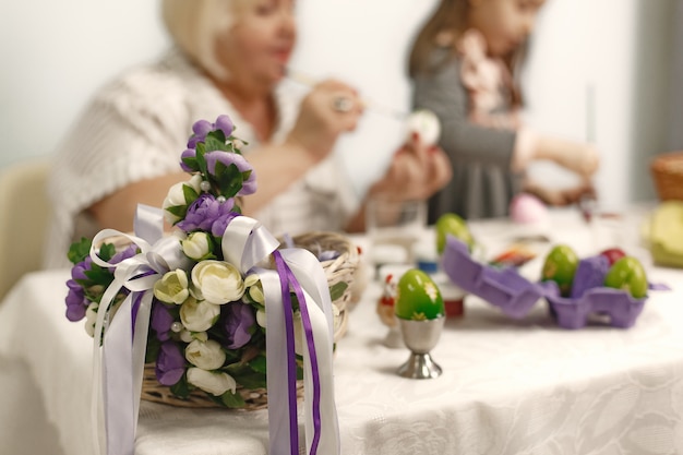 Osterkonzept. Kleines Mädchen und ihre Großmutter färben Eier für Ostern. Nahaufnahmefoto.