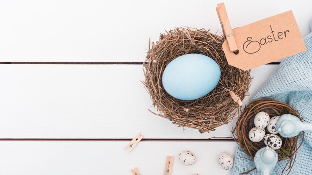 Ostern-Aufschrift mit blauem Ei im Nest