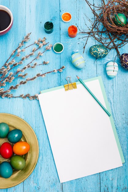 Ostern im Büroarbeitsplatz auf blauem Holztisch.