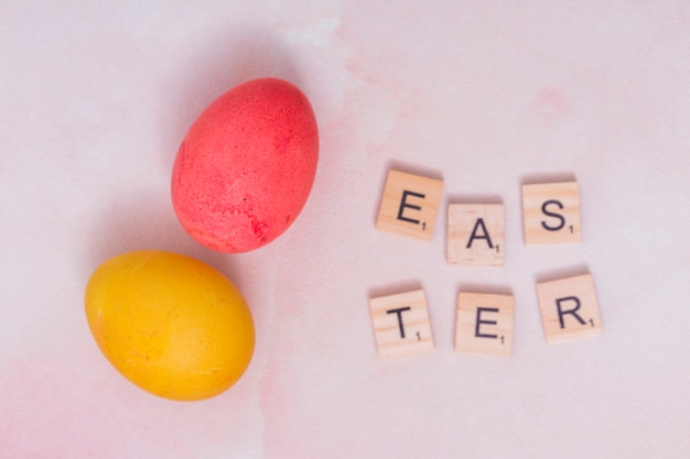 Kostenloses Foto ostern-inschrift mit bunten eiern