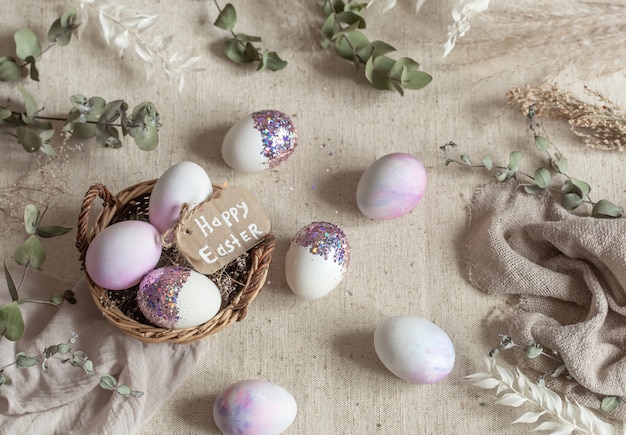 Ostern Stillleben mit Eiern mit Pailletten in einem Weidenkorb verziert. Glückliches Osterkonzept