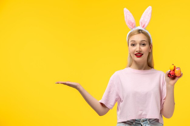 Ostern süßes junges blondes Mädchen mit rosa Hasenohren, die Ostereier halten