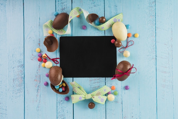 Ostern Süßigkeiten und Bänder um schwarzes Papier