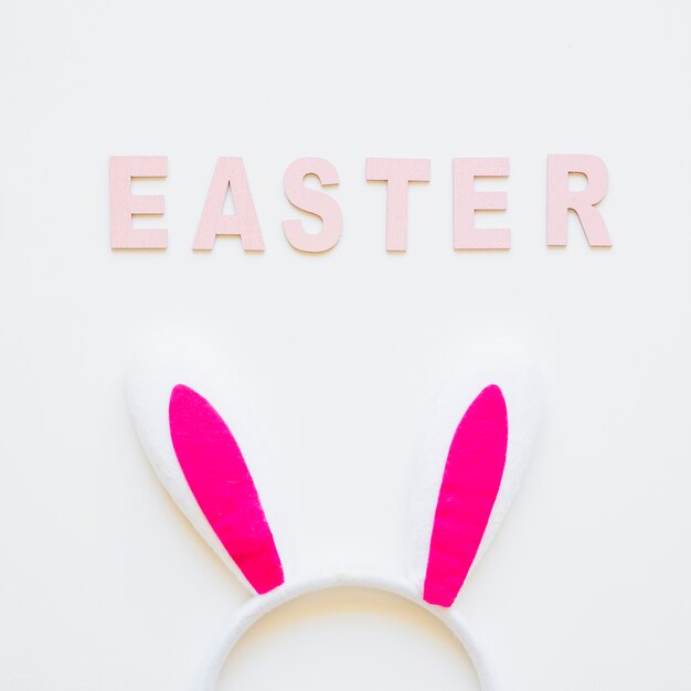 Ostern-Wort und rosa Hasenohren