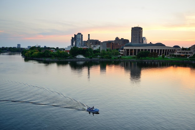 Kostenloses Foto ottawa-sonnenuntergang über fluss mit historischer architektur.