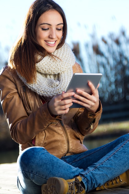 Outdoor Porträt der jungen Frau mit digitalen Tablette