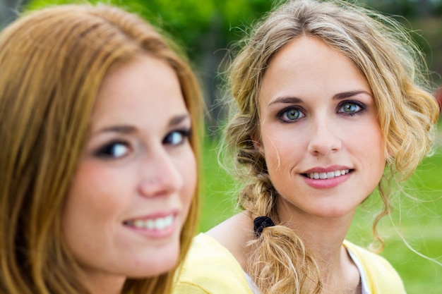 Outdoor Portrait von zwei schöne junge Frauen posiert im Park