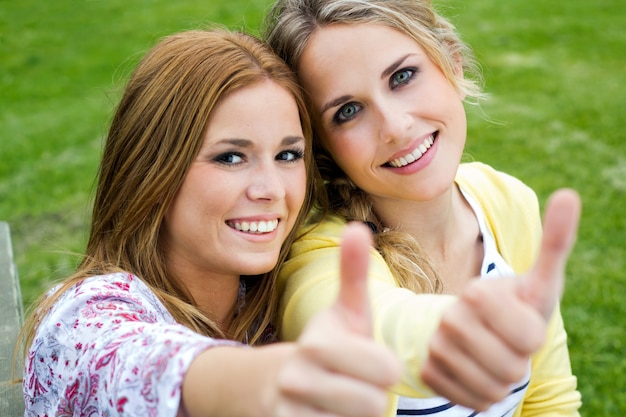 Outdoor Portrait von zwei schöne junge Frauen posiert im Park