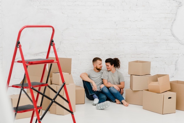 Kostenloses Foto paar auf dem boden in der neuen wohnung