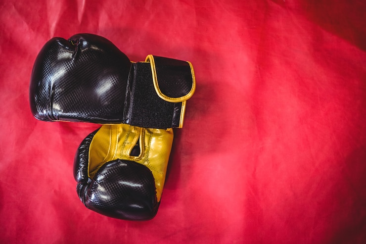 Kostenlose Foto paar boxhandschuhe auf roter oberfläche