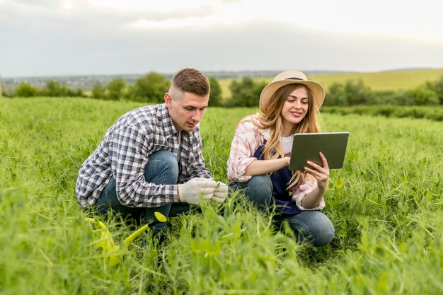 Paar, das am Bauernhof mit Tablette arbeitet