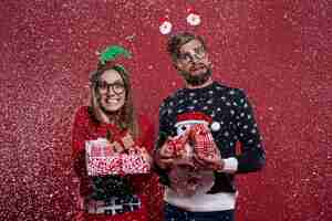 Kostenloses Foto paar, das einen stapel weihnachtsgeschenke trägt