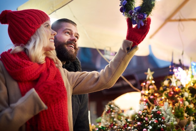 Paar, das Weihnachtskränze nach oben schaut