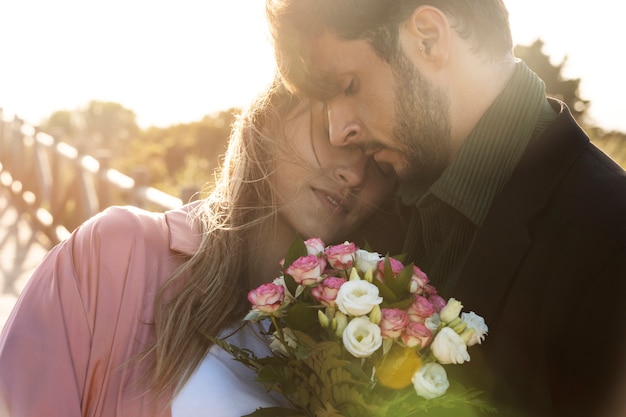 Kostenloses Foto paar des hohen winkels mit blumen