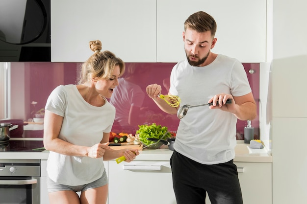 Paar drinnen, das das Essen zubereitet