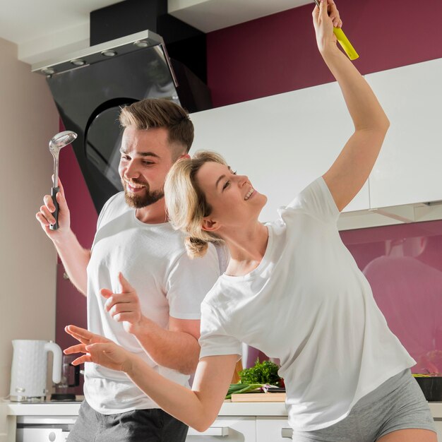 Paar drinnen glücklich sein und in der Küche tanzen