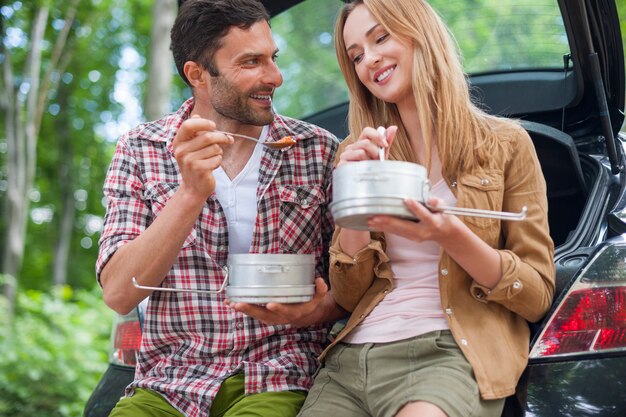 Paar essen im Auto, bevor Sie wandern gehen