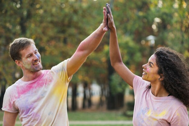 Kostenloses Foto paar high-fiving einander in holi