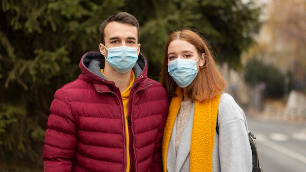 Paar im Freien mit medizinischen Masken