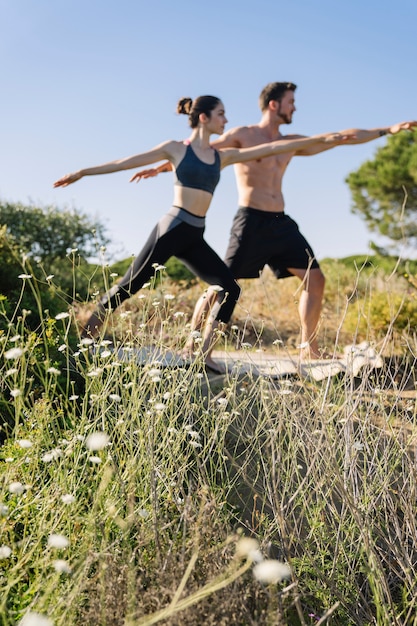 Kostenloses Foto paar macht yoga-übung am strand