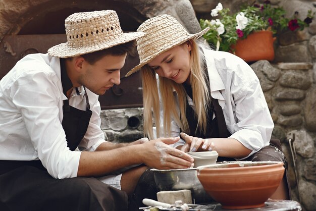 Paar mit braunen Schürzen machen eine Vase