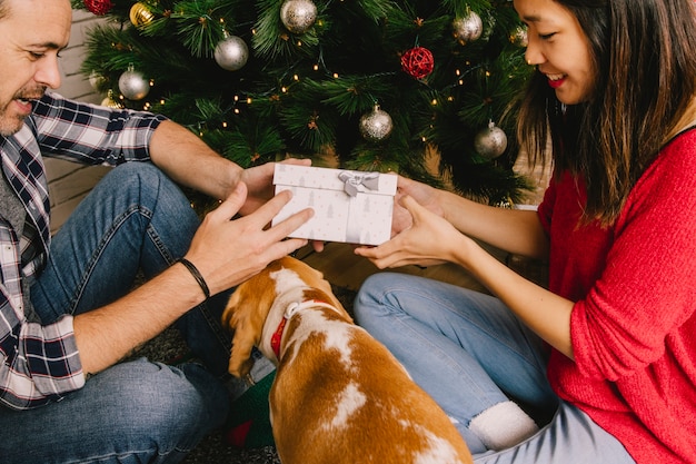 Paar mit dem Hund, der Geschenk austauscht