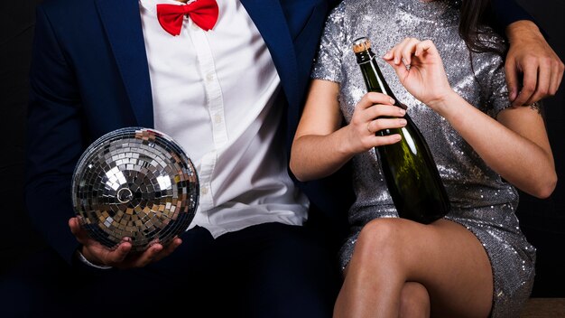 Paar mit Discokugel und Flasche Champagner