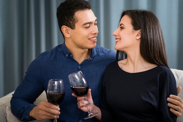 Paar mit einem Glas Wein beim Sitzen auf der Couch