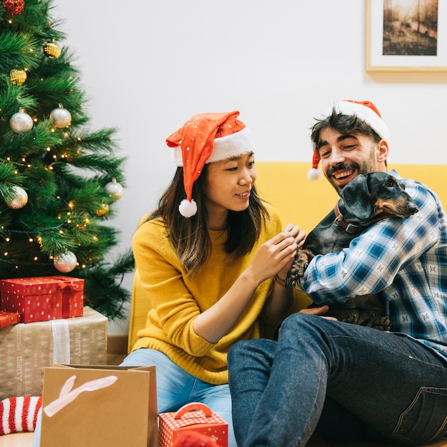 Kostenloses Foto paar mit hund zu weihnachten