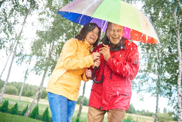 Paar mit Regenbogenregenschirm